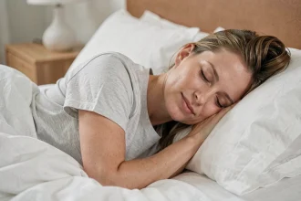 Femme de 35 ans dormant paisiblement dans une chambre minimaliste, illustrant l'importance du sommeil pour le contrôle du poids corporel